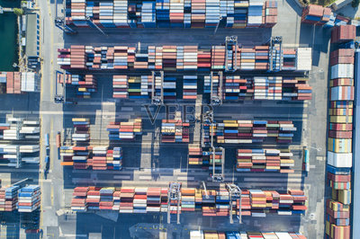 有集装箱的工业港口。集装箱船在进出口业务和物流。用起重机将货物运到港口。国际水路运输。鸟瞰图照片摄影